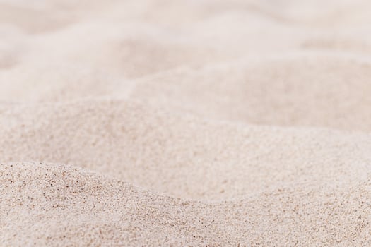 Fine Sand texture natural surface. Close up of sand on shore sea, white waves dunes, pink neutral color, minimal nature aesthetics wallpaper. Sandy beach for background, selective focus photo