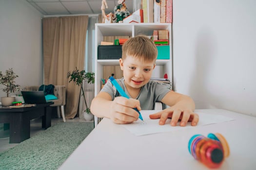 smiling boy focused on drawing at his study desk in a bright room, concept of early education, creativity in children, home schooling photo