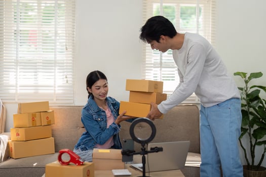 Entrepreneurship and Collaboration. A young woman and man are unboxing and preparing packages together for their new business venture. photo