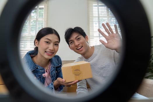 Branding and Product Promotion. A joyful couple showcasing their product box while preparing for an online presentation. photo
