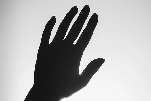 A hand is shown in silhouette against a white background photo