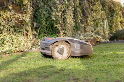 Robotic Lawn Mower on green grass background.Automatic robot lawnmower in modern garden photo