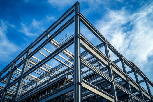 Steel frame structure rising against a blue sky during construction photo