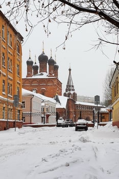 Krutitsy Metochion view from Krutitskaya street in winter snowfall, Russia landmark. Russian Orthodox Church black domes. Moscow photo