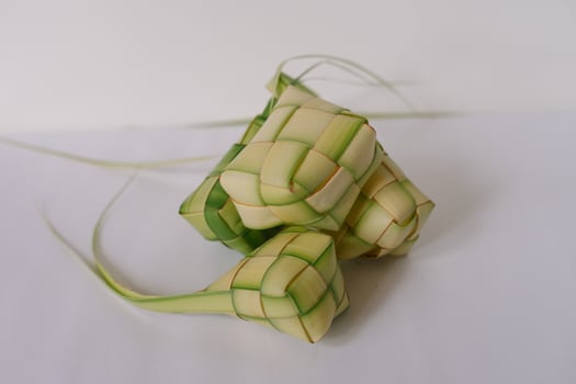 Three Ketupat On White Surface, Traditional Rice Dumpling for Festive photo