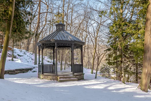 A gazebo in the middle of a snowy forest photo