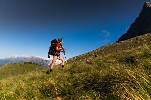 Smiling female traveler with black hiking backpack enjoying beautiful landscape of majestic mountains. Travel, adventure. Active lifestyle concept photo