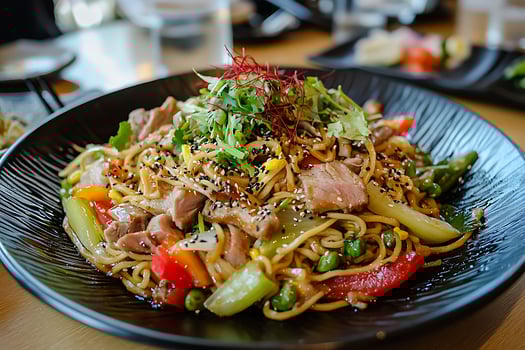 A plate of noodles with meat and vegetables photo