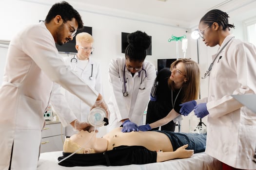 Doctors practicing cardiopulmonary resuscitation and intravenous injection on medical manikin. photo