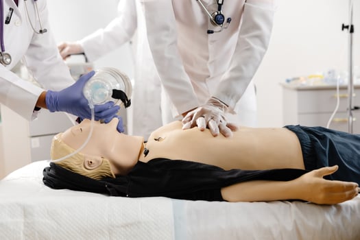 Doctors practicing cardiopulmonary resuscitation on a medical manikin photo