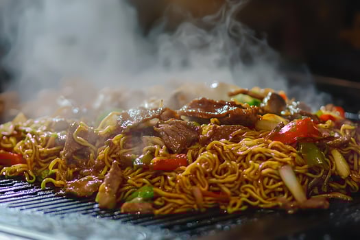 Steaming Hot Noodles with Beef and Vegetables on a Griddle. A delicious and savory dish perfect for a quick meal. photo