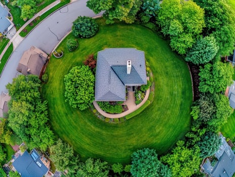 Green circular garden surrounds a home in a suburban neighborhood photo