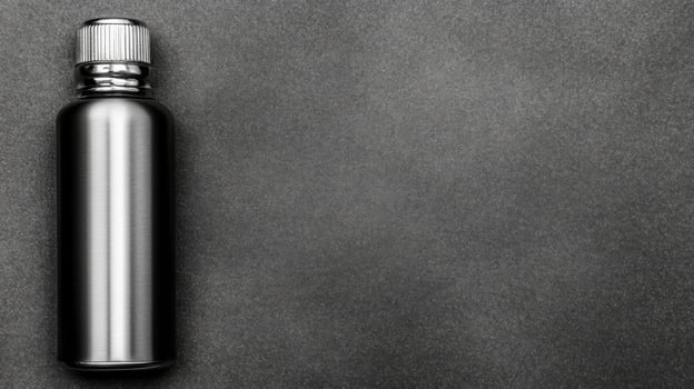 Silver Metal Flask on Dark Gray Textured Surface photo