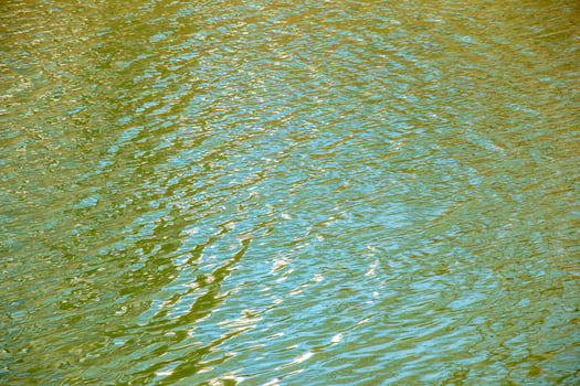 Water surface in sunset rays, river ripples or ocean with small waves, calm and close-up. Natural background. Abstract background. photo