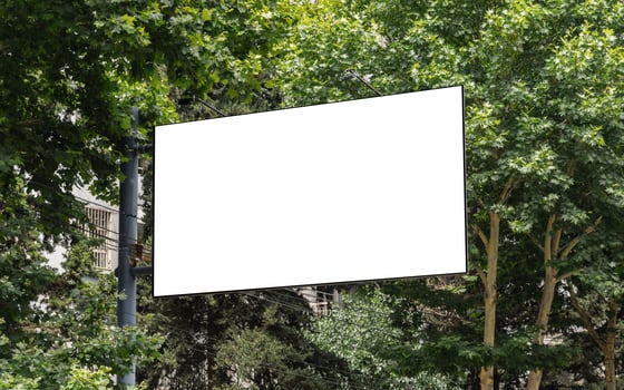 Blank white billboard on a pillar among trees. Template photo