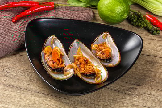 A black plate with three clams on it photo