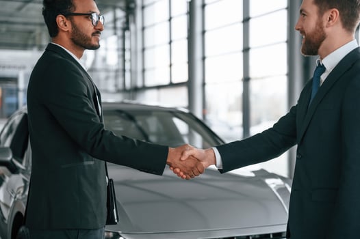 Two businessmen, are working together in the car showroom photo