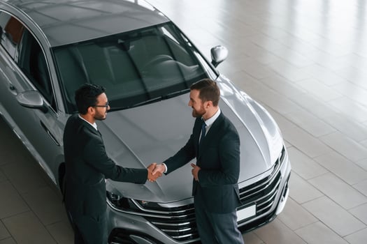 Doing handshake.. Two businessmen are working together in the car showroom photo