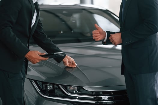 Near grey ,colored automobile. .Two businessmen are working together in the car showroom photo