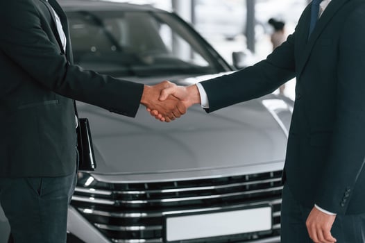 Close up view. Two businessmen are ,standing in the car showroom and making a deal, handshake photo