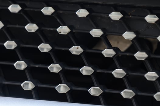 Intricate Pattern of Metallic Hexagons on a Black Grille in Natural Light photo