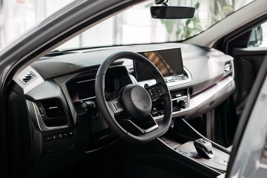 A vehicle with brown seats and a steering wheel, showcasing an elegant automotive design inside. The personal luxury car has a sleek interior photo
