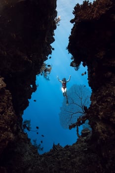 Woman freediver posing in underwater cave in Menjangan photo
