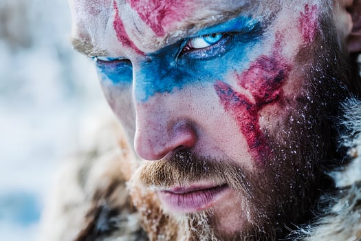Intense close-up portrait of a man with a beard and artistic face paint, creating a dramatic and expressive look photo
