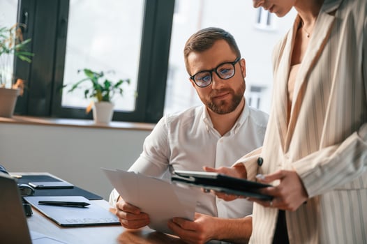 Woman ,is holding tablet, analysing information. Two employees are working together in the modern office photo