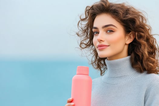 Young woman enjoying casual outdoor fashion while holding a coral water bottle in a serene neutral-toned environment photo