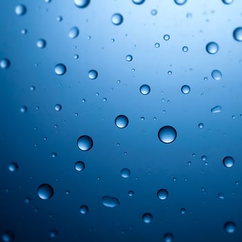 This close-up image showcases numerous water droplets on a smooth, deep blue surface. photo