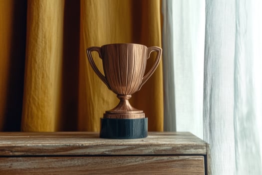 A bronze trophy sits on a wooden table photo