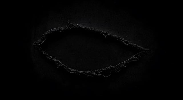 Dark textile with a dramatic rip in the center, showcasing a rugged and distressed texture. Fabric rips texture. photo
