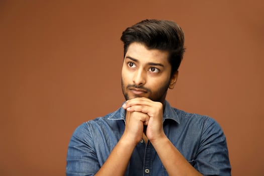 Handsome Indian model contemplating with his hands on his chin photo