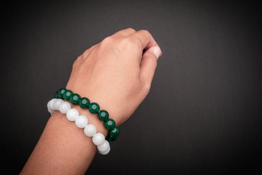 Jade bangles or bracelets on wrist against a black background photo