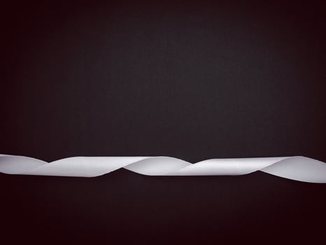 Top view of a white ribbon and wooden cubes with the letters RIP on a black background. photo