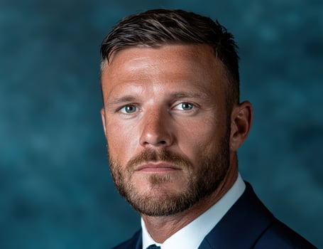 Professional headshot of a man in a suit against a blue background photo