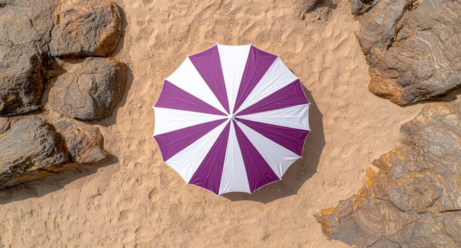 Purple and white beach umbrella on a sandy beach photo