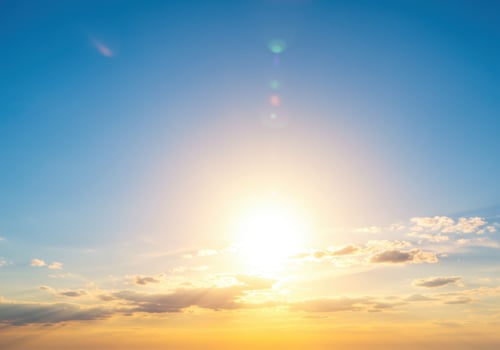 Golden sunrise paints the horizon with soft clouds gently drifting in a blue sky. photo
