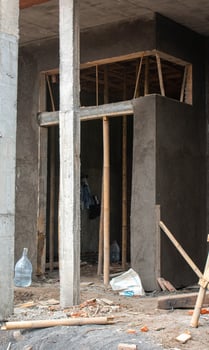A man is standing in front of a building with a construction sign photo