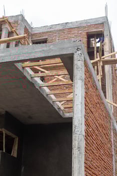 A building under construction with red brick and cement photo