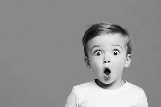 A young boy is making a surprised face photo
