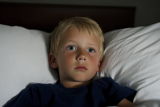 A young boy laying in bed photo