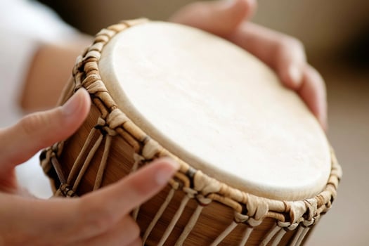 A person is playing a drum with their hands photo