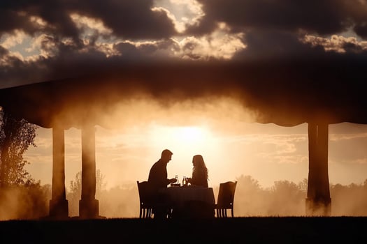 A couple is sitting at a table under a gazebo at sunset photo