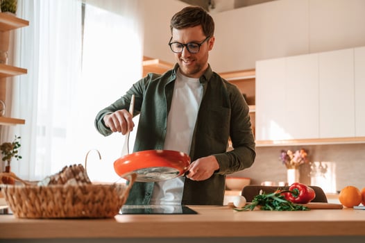 Preparing the food.. Handsome man is on the kitchen at daytime photo