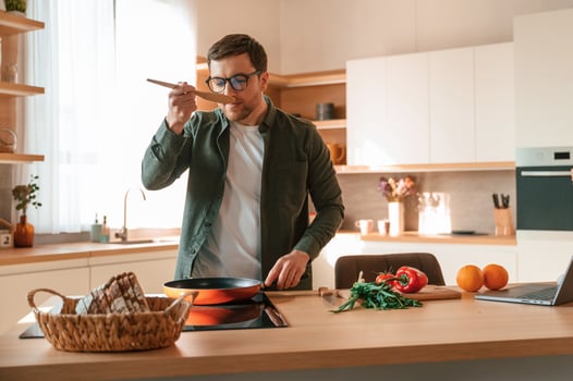 Preparing .the food. Handsome man is on the kitchen at daytime photo