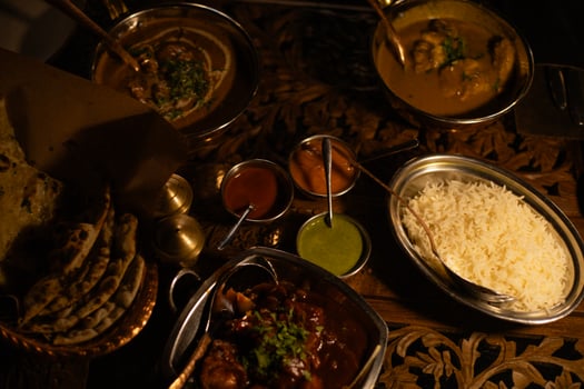 Indian dishes on plates and a plate of white rice next to it photo
