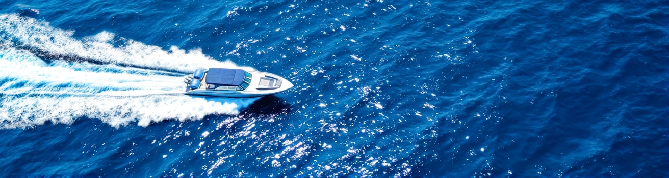 sleek motorboat speeding across a vivid blue ocean photo
