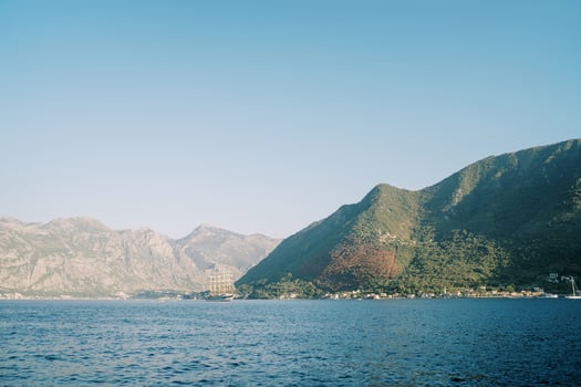 Large ship sails on the sea against the backdrop of green mountains photo